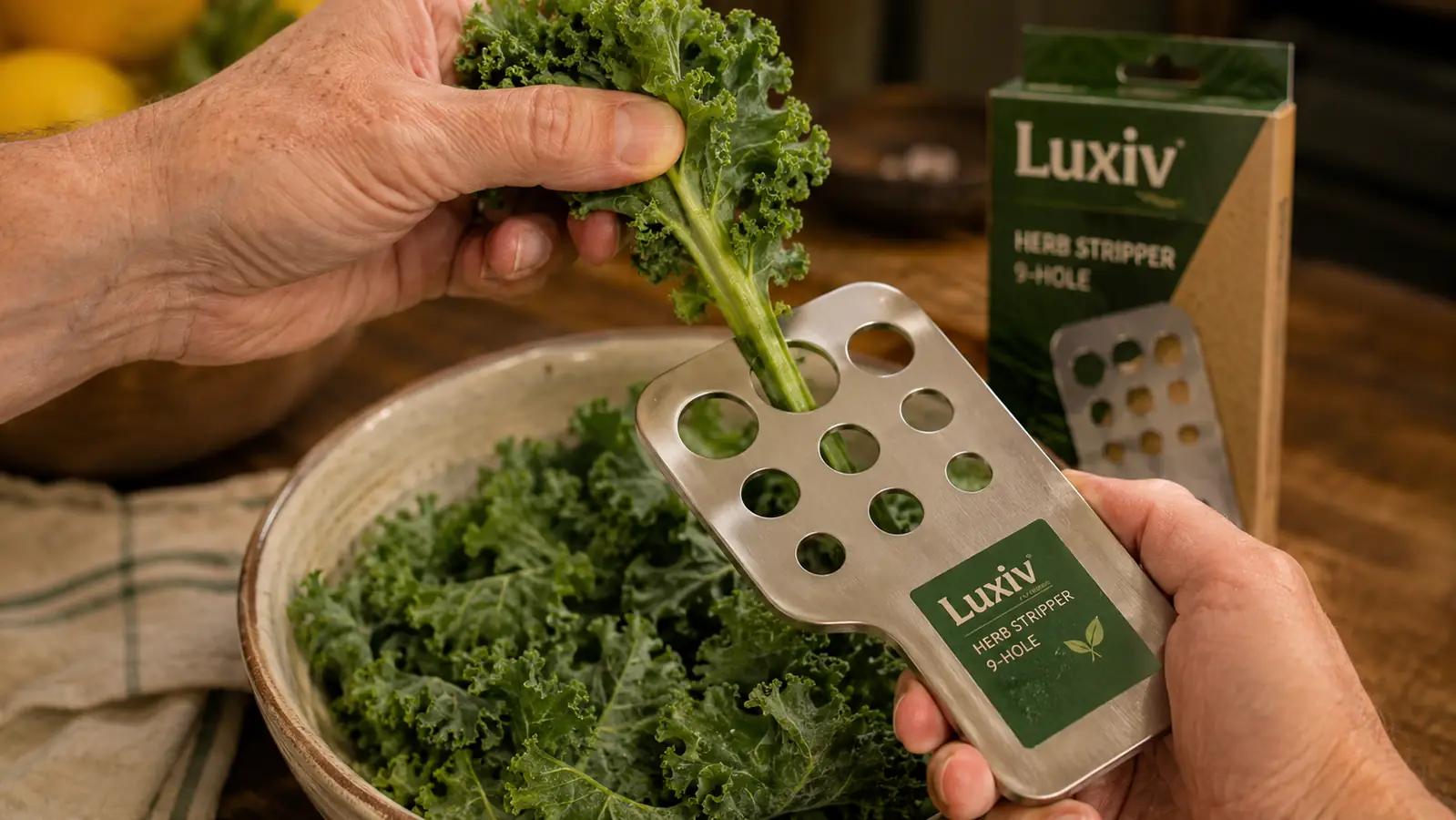 Close-up of a hand pulling a kale stem through the largest hole of a herb stripper, leaves separating from the stem