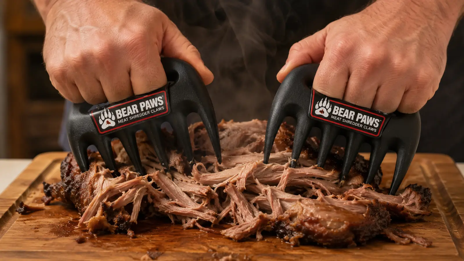 Close-up of hands using Bear Paws meat claws to pull apart shredded pork on a wooden cutting board